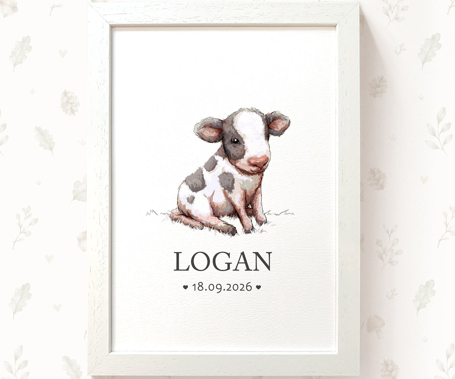 A framed personalized baby nursery print featuring a watercolor illustration of a black and white calf. The print is personalized with the name 'LOGAN' and the date '18.