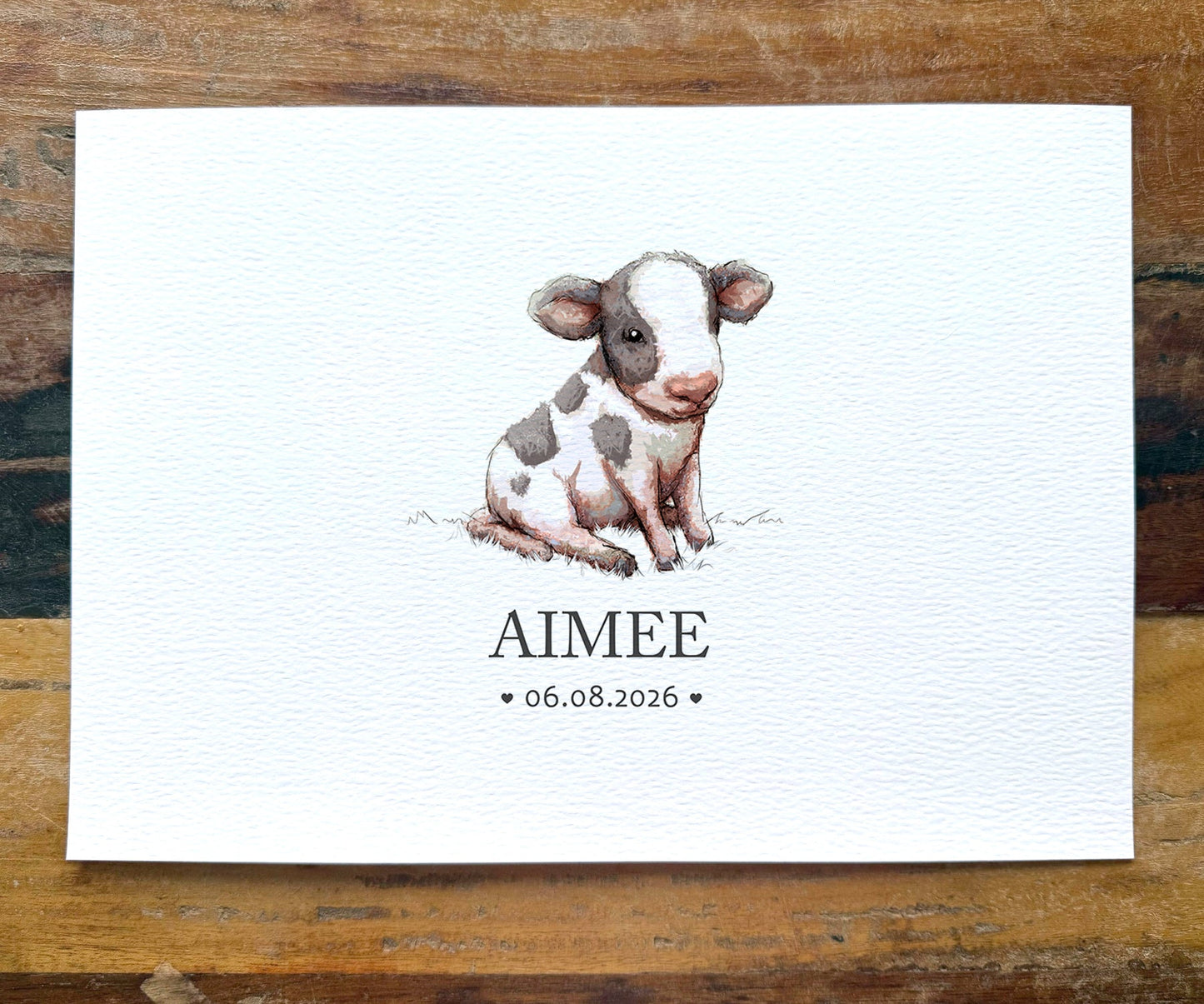 A personalized baby shower favor card featuring a watercolor illustration of a spotted calf named 'AIMEE' with the date '06.08.