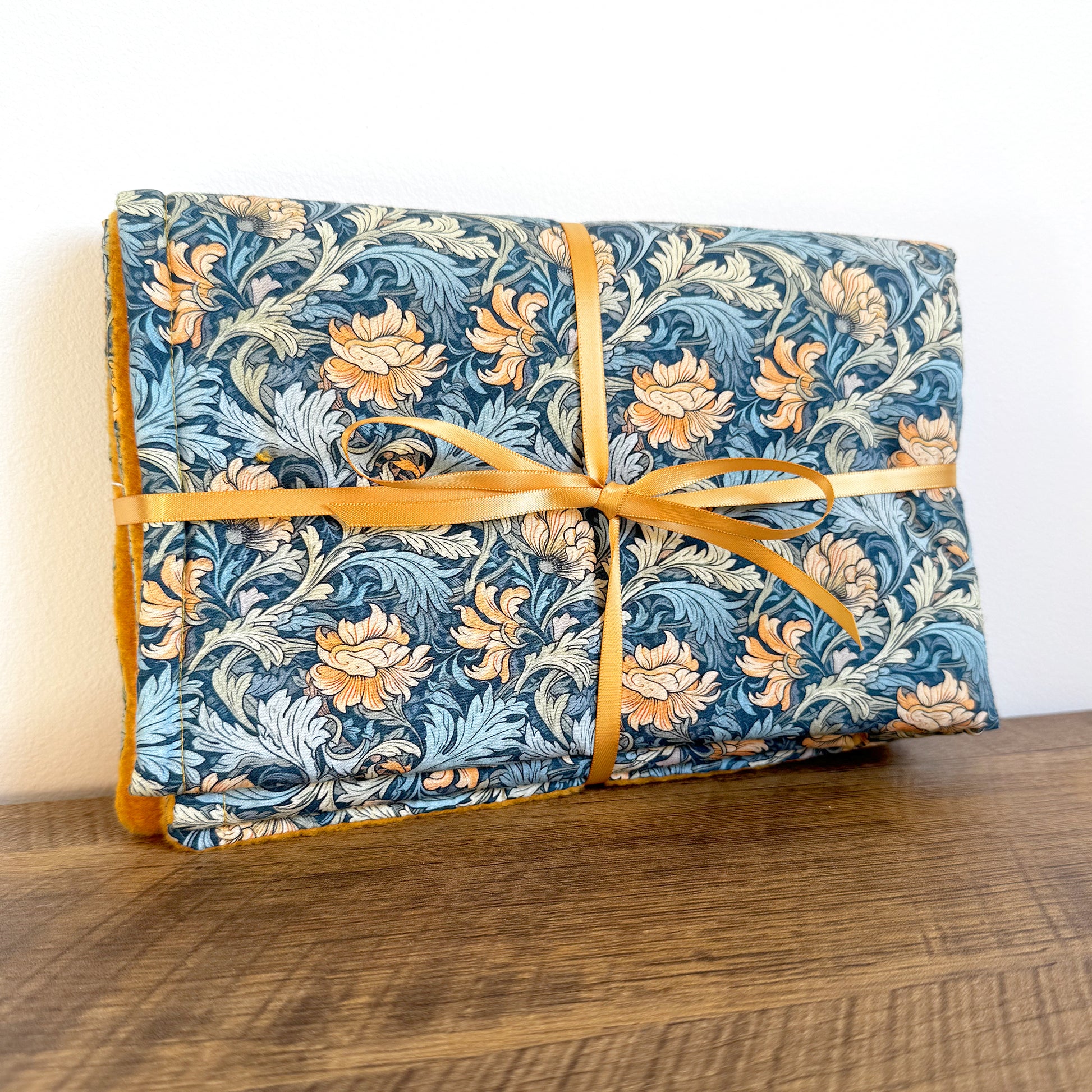 Handmade dog blanket folded and tied, showing cotton patterned top and fleece backing