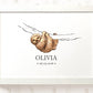 A framed personalized art print featuring a watercolor illustration of a brown sloth hanging from a branch, with the name 'OLIVIA' and the date '06.05.