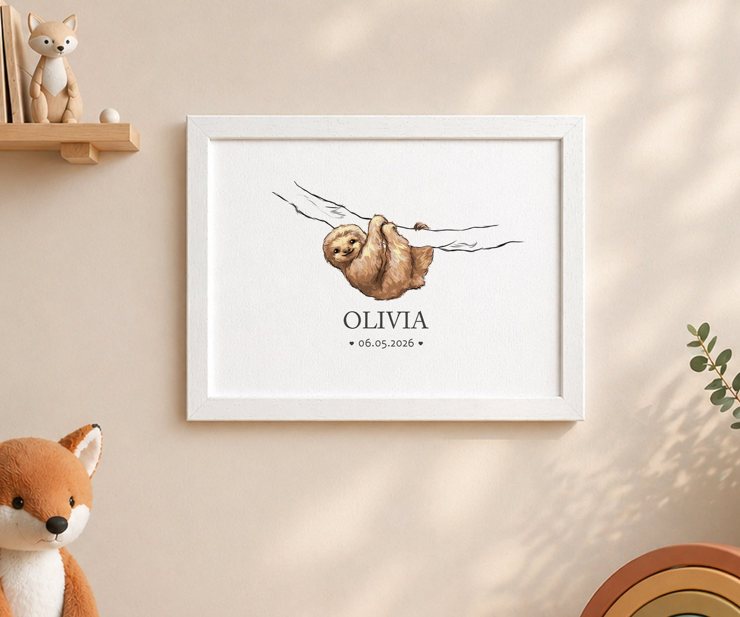 A framed personalized art print featuring a watercolor sloth hanging from a branch with the name 'OLIVIA' and the date '06.05.